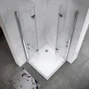 A corner shower cabin with glass doors and a white base, set against marble-tiled walls and gray tiled flooring. A small rug with a geometric pattern is placed on the floor in front of the shower. Produktbild-Vorschau