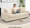 A woman is sitting on a cream-colored sofa, using a laptop. The sofa is in a living room setting with a rug and plants in the background. Náhľad obrázku produktu