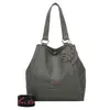 A grey shoulder bag with a leaf charm and a detachable strap.