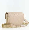 A studio shot of a beige quilted handbag with a gold strap. Anteprima dell’immagine prodotto