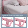 Close-up of a pink metal bed frame with a mattress and pillows, showing a detail of the mattress support system. Produktbild-Vorschau