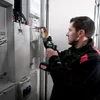 An electrician is working on an electrical panel with a cordless drill. Anteprima dell’immagine prodotto