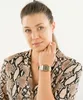 A woman wearing a snake-print shirt and a gold digital watch. Voir les images du produit