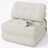 A beige corduroy sofa/chair with a magazine on it, set against a white background. Produktbild-Vorschau