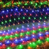 A net of colorful LED lights is draped over grass and bushes, likely for outdoor decoration. Produktbild-Vorschau