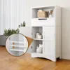 A white bathroom cabinet with its doors open, showing internal shelves and items. A close-up inset highlights adjustable shelves. Náhled obrázku produktu