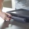 A person's hand is shown adjusting a part of a black grill. Podgląd zdjęcia produktu