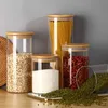 A set of glass storage jars with bamboo lids filled with various food items. Produktbild-Vorschau