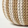 A close-up view of a knitted pouf with alternating beige and white stripes. Produktbild-Vorschau