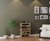 A living room scene featuring a wooden wine rack filled with bottles, two potted plants, and a couch with decorative pillows. Náhled obrázku produktu