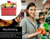 A woman is smiling and holding fresh produce in a grocery store aisle. A red shopping basket is shown in a circular inset on the left. Produktbild-Vorschau