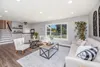 A bright and airy living room with a sofa, chairs, coffee table, and a large window overlooking a suburban street. Podgląd zdjęcia produktu