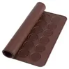 A brown silicone baking mat with circular indentations for baking macarons or other small treats. The mat is partially rolled. Podgląd zdjęcia produktu
