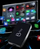 A black electronic device with the logo 'B Play' is shown in front of a car infotainment screen displaying various app icons. Náhľad obrázku produktu