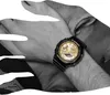 A close-up shot of a person's wrist wearing a black and gold Casio G-Shock watch. Produktbild-Vorschau