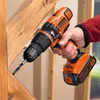 A person is using a Black & Decker cordless drill to drill into a wooden structure. Produktbild-Vorschau