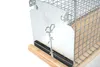 A close-up view of a live animal trap, showing its metal and wood construction. Produktbild-Vorschau