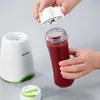 A person is holding a blender cup filled with a red smoothie, and the blender base is on the side. Podgląd zdjęcia produktu