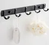 A black metal hook rack mounted on a white tiled wall in a bathroom. Voir les images du produit