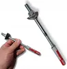 A hand holding a metal post anchor with a plastic dowel, with a larger version of the same anchor in the background. Anteprima dell’immagine prodotto