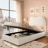 A bedroom scene with a white upholstered bed frame open to reveal storage underneath. The room has pink walls and a large window with sheer curtains. Anteprima dell’immagine prodotto