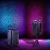 Two portable speakers are displayed in a room with a brick wall and colorful lighting. Produktbild-Vorschau