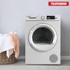 A white Telefunken heat pump dryer is shown in a room with a laundry basket filled with towels next to it. Produktbild-Vorschau