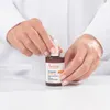 Hands holding a bottle of serum. Anteprima dell’immagine prodotto