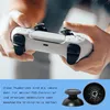 A person is holding a white PS5 controller, with replacement thumbsticks shown below. Produktbild-Vorschau