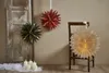 Christmas decorations hanging on a wall and a chair, with candles on the floor. Podgląd zdjęcia produktu