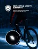 A person riding a bicycle at night, with reflective elements on their clothing. Podgląd zdjęcia produktu