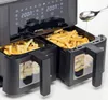 A close-up shot of a dual-basket air fryer with french fries in both baskets. A spoon is pouring oil into one of the baskets. Produktbild-Vorschau