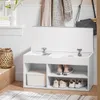 A white shoe bench with storage is shown in an entryway, with shoes and a storage box inside. A basket and a vase with flowers are to the left, and scarves and a bag are hanging on the wall behind. Anteprima dell’immagine prodotto