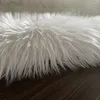 A close-up view of a white faux fur rug lying on a dark wooden floor. Náhľad obrázku produktu