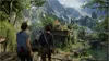 Two men stand on a wooden platform overlooking a lush, overgrown jungle with ancient ruins in the distance. Náhled obrázku produktu