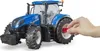 A hand is shown interacting with a toy tractor. Voir les images du produit