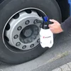A person is using a spray bottle to clean a truck tire. Produktbild-Vorschau