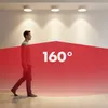 A person walking in a room with ceiling lights, with a red overlay indicating a 160-degree detection angle. Anteprima dell’immagine prodotto