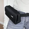 A person wearing a black belt with a black pouch attached. Podgląd zdjęcia produktu