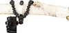 A camera is attached to a flexible tripod wrapped around a tree branch. Produktbild-Vorschau