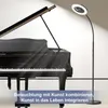 A grand piano is illuminated by a floor lamp with a built-in fan and light. Anteprima dell’immagine prodotto