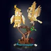Two golden cockatiel figures are perched on a brown tree branch, with a dark background. Náhľad obrázku produktu