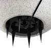 Close-up view of the underside of a speckled white lamp base with black spikes. Náhled obrázku produktu