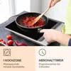 A person is using an induction cooktop to cook food, with product features highlighted in the lower section. Produktbild-Vorschau
