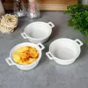 Three white ceramic ramekins are arranged on a gray countertop. One ramekin contains a baked dish with melted cheese, while the other two are empty. In the background, there are salt and pepper shakers, a bundle of uncooked pasta, and some greenery. Náhled obrázku produktu