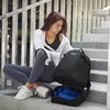A woman is sitting on stairs with a backpack next to her, which has shoes in its compartment. Produktbild-Vorschau