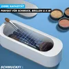 A white ultrasonic cleaner filled with makeup brushes and powder compacts. Produktbild-Vorschau