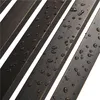A close-up view of a dark metal bench with water droplets on its surface. Produktbild-Vorschau