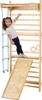 A young girl is playing on a wooden gym set indoors. Podgląd zdjęcia produktu