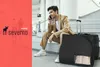 A man sitting on stairs in an airport with luggage and a garment bag. Anteprima dell’immagine prodotto